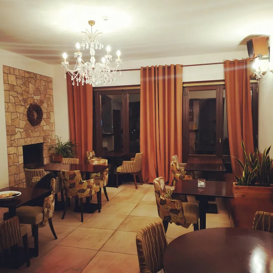 Το σαλόνι με το πέτρινο τζάκι και τις κουρτίνες
